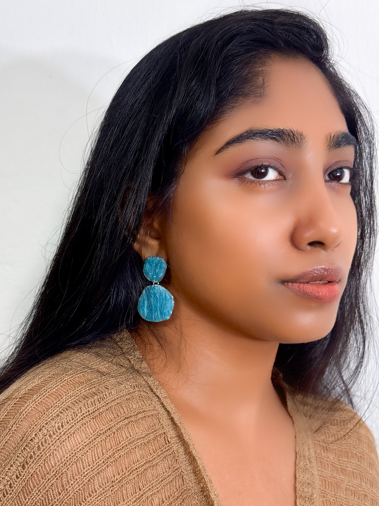 Dangle sea blue statement earrings with layered circular pattern styled as statement jewel