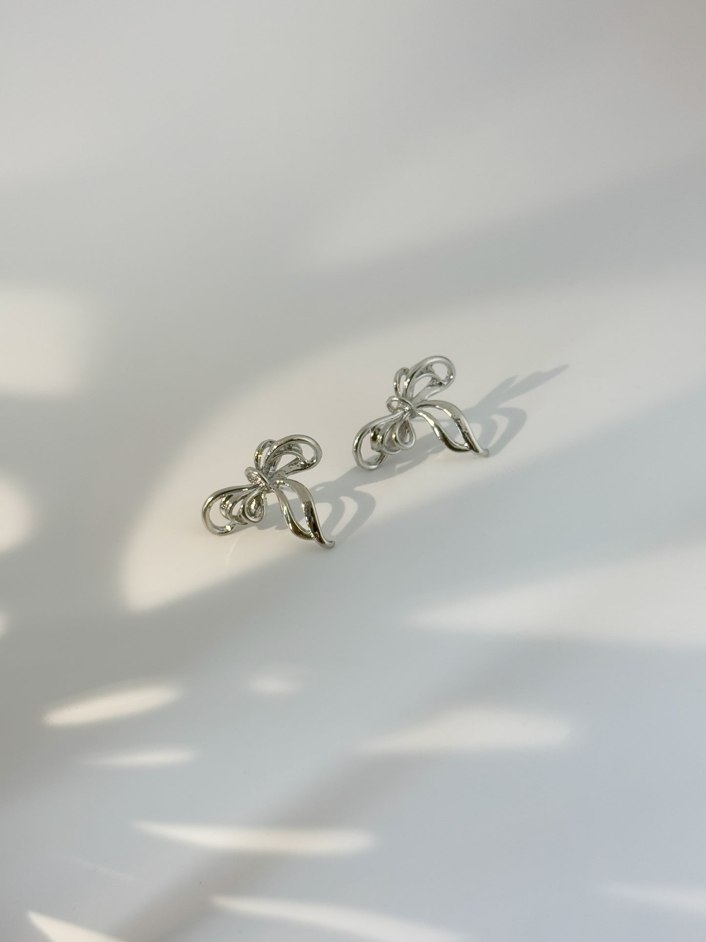 Dainty bow-shaped sterling silver stud earrings