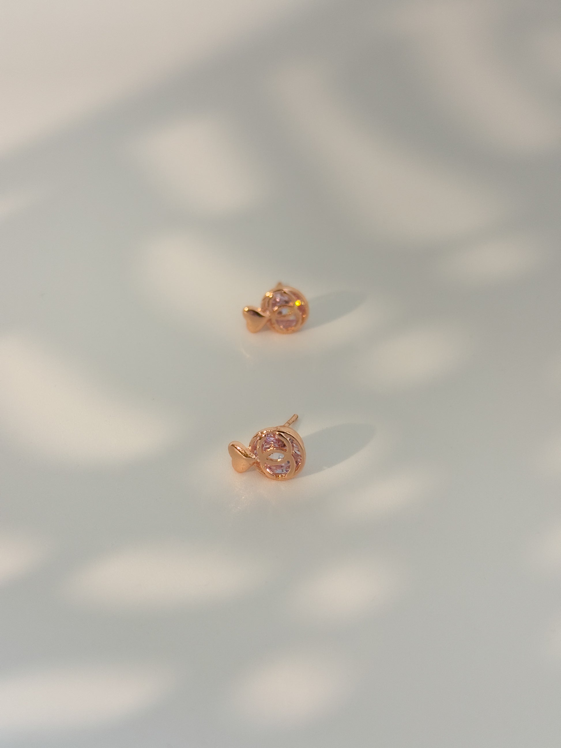 Rose gold earrings on a light background