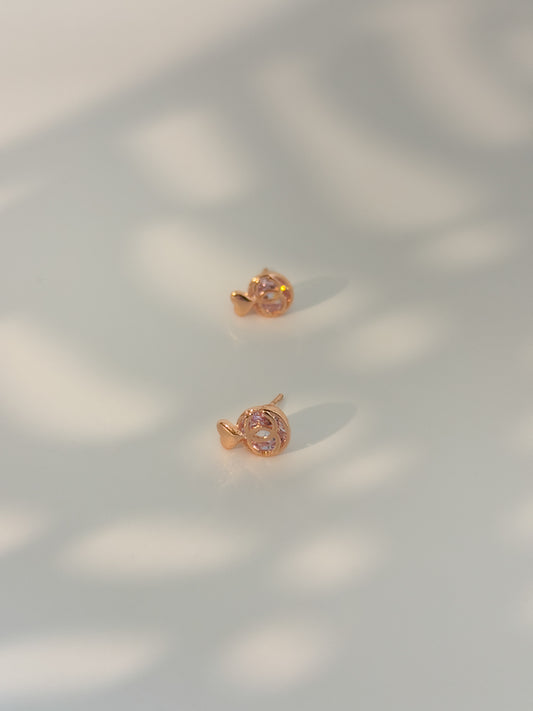 Rose gold earrings on a light background