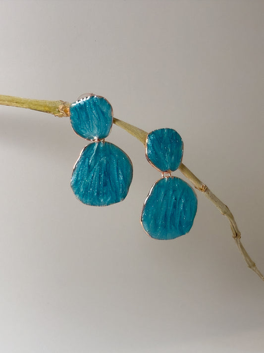 Dangle sea blue statement earrings with layered circular pattern styled as statement jewel