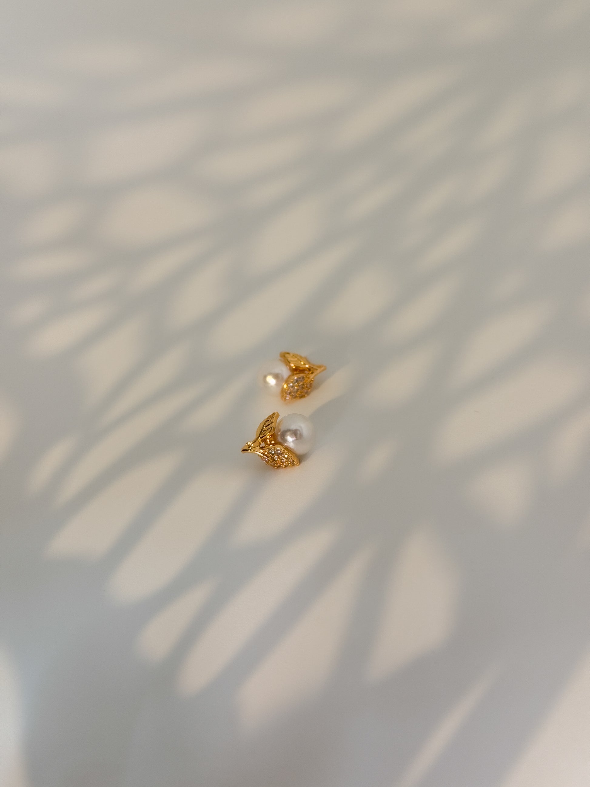 Gold earrings with pearls on a minimal style