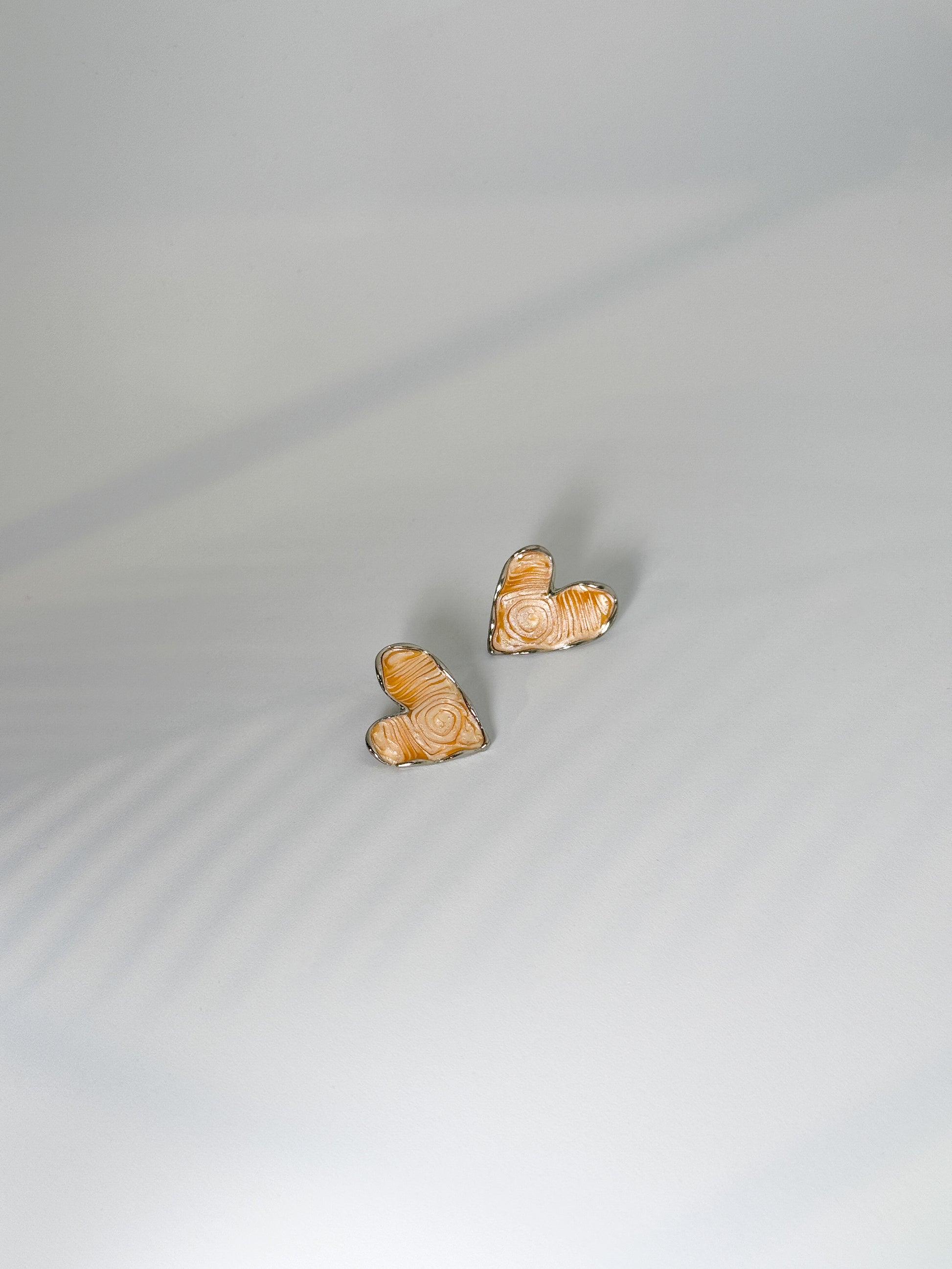 daily wear, Heart-shaped beige textured stone stud earrings with silver outline, minimal design