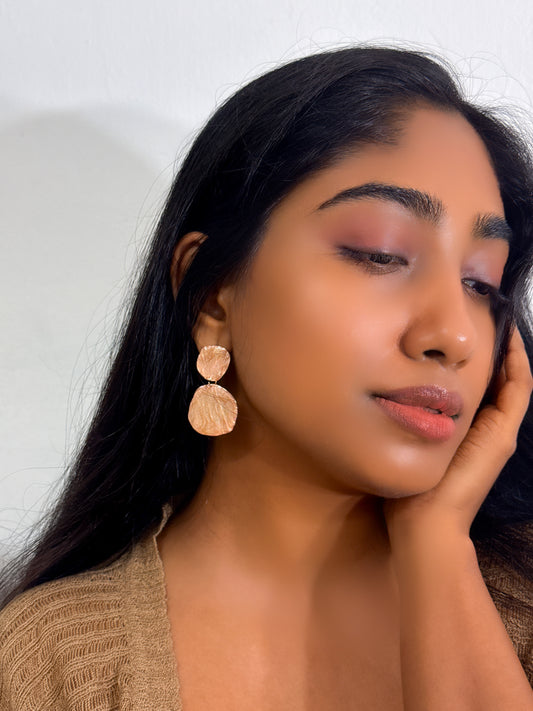 wearing a golden dangle earrings in a textured biscuit color pop