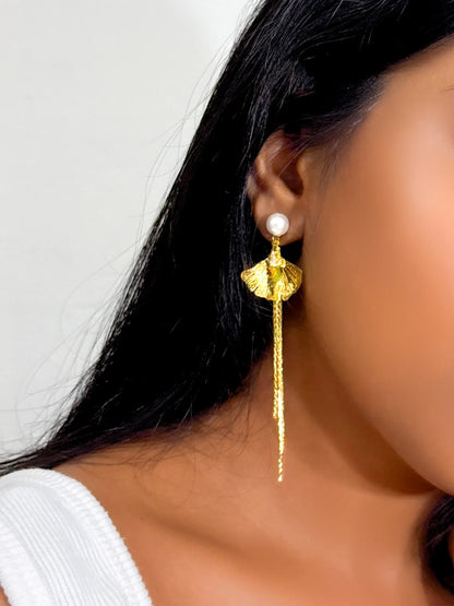 wearing a bold statement long statement earrings with a pearl