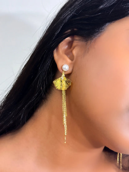 Gold tassel earring with pearl detail worn in a dusky skintone