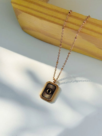 Anti Tarnish Gold necklace with a square pendant on a wooden block | Minukki