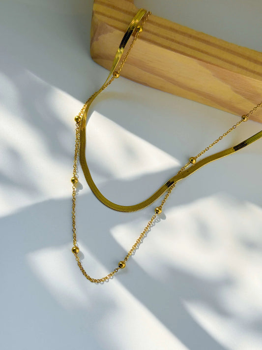 Anti Tarnish double layered Gold necklace on a white surface with a wooden block