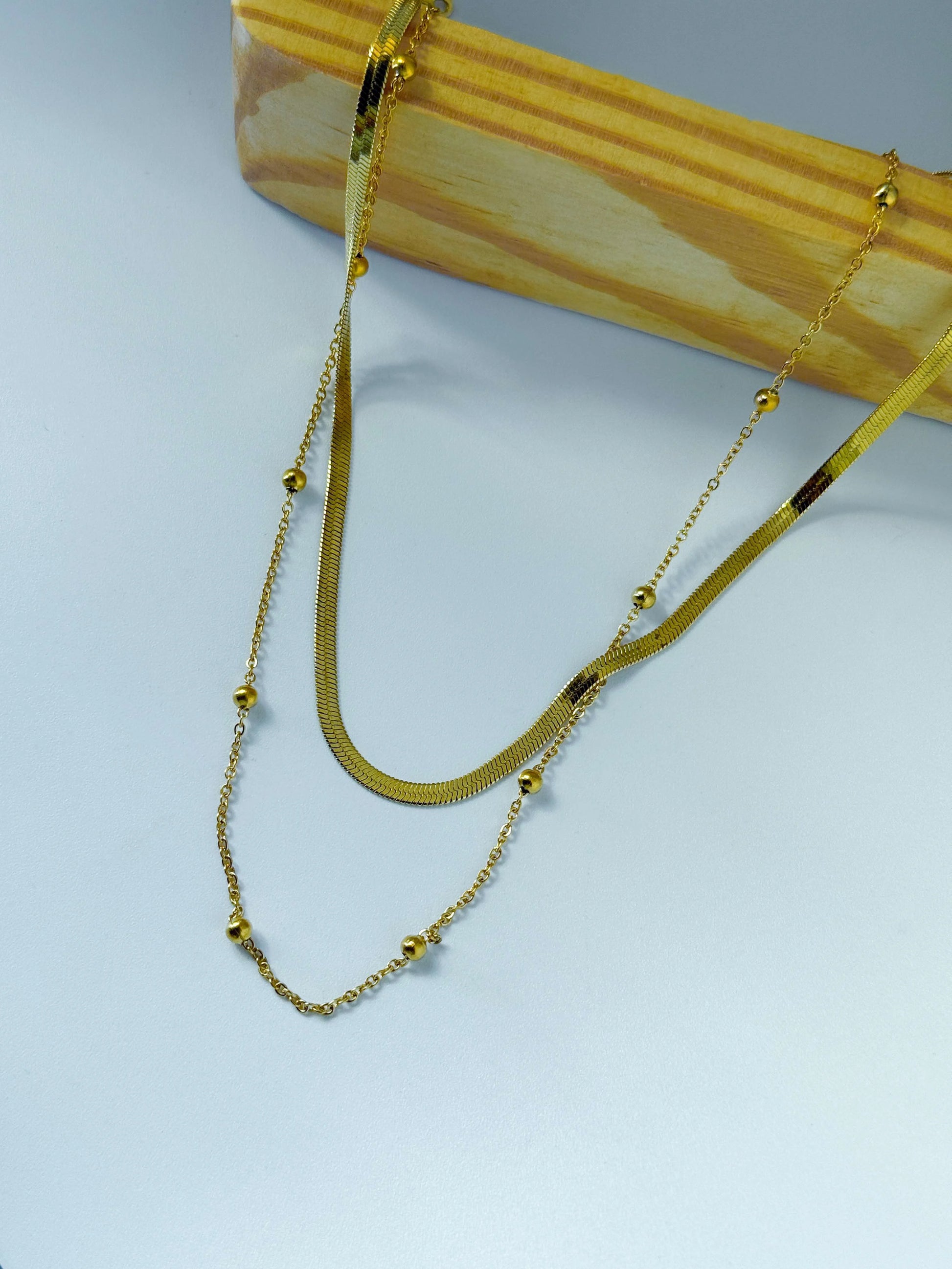 Anti Tarnish double layer gold necklace on a wood